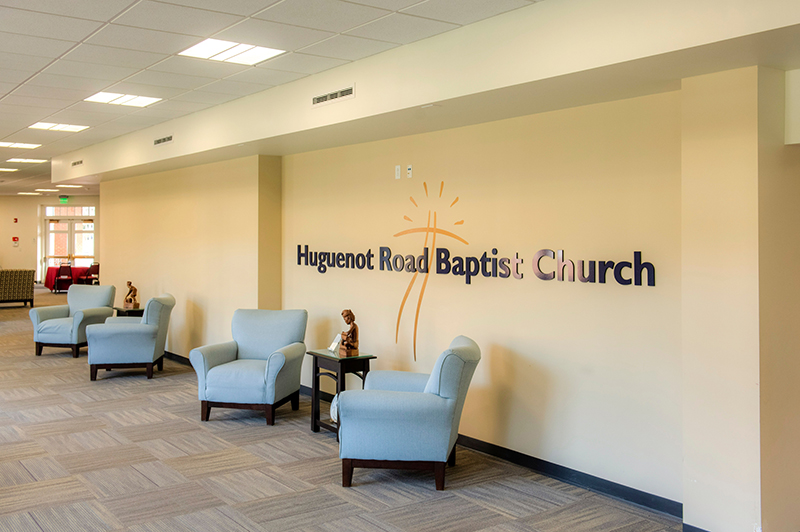 Image of Lobby. Blue chairs with Huguenot Road Baptist Church logo on wall