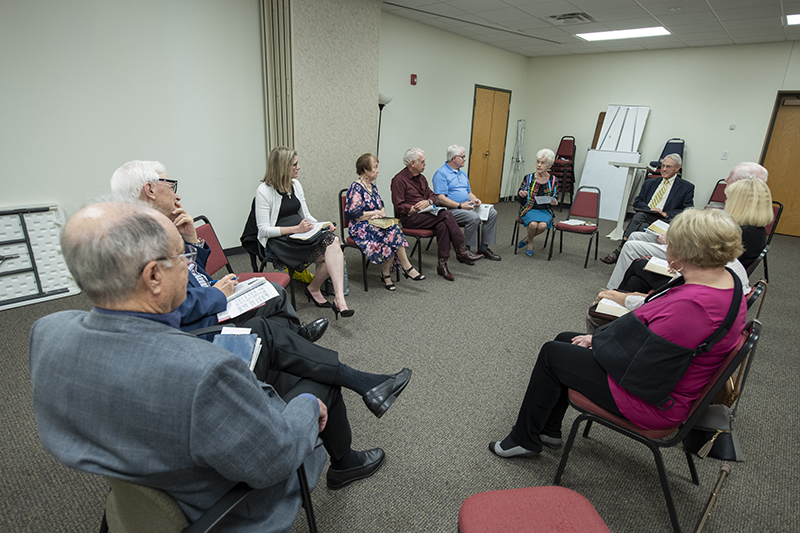 Senior adults sit in a circle in a classroom at HRBC.
