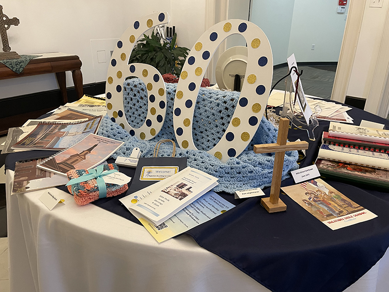 Table decorated with large 60, containing Heritage Day memorabilia. 