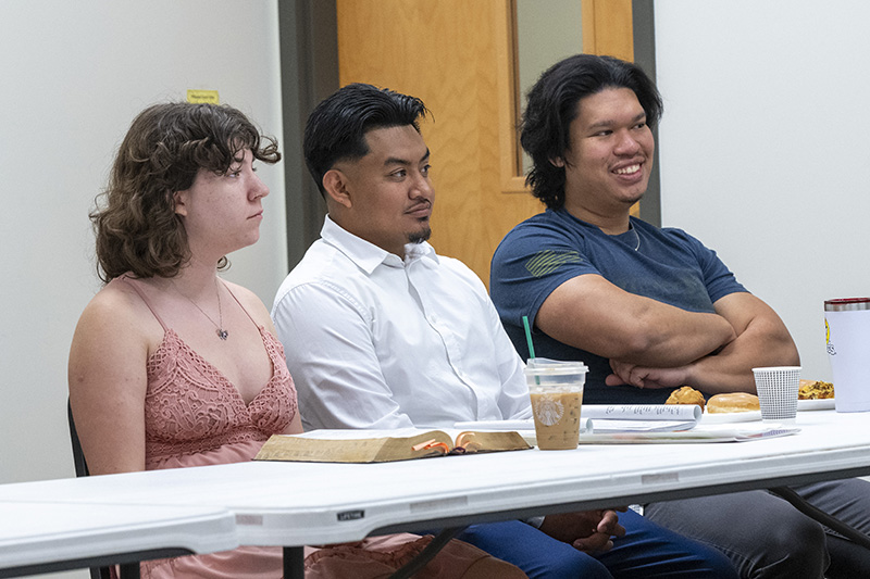 3 young adults listen during a class at Huguenot Road Baptist Church